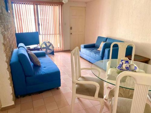 a living room with a blue couch and a glass table at Depto a 3 cuadras de la playa in Boca del Río