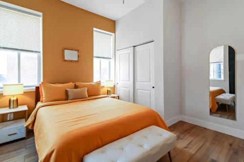 a bedroom with an orange bed and a chair at Mardi Gras Hideaway Cozy 2BR in Soulard in Soulard