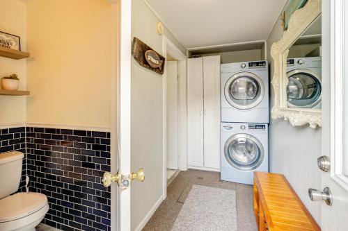 a bathroom with a washer and dryer and a toilet at Scenic Ludington Home about 1 Mi to Lake Michigan in Ludington