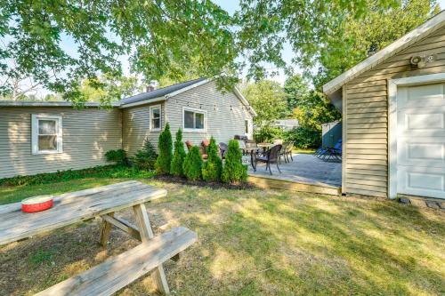 a backyard with a wooden bench in front of a house at Scenic Ludington Home about 1 Mi to Lake Michigan in Ludington