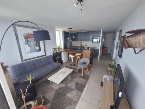 een woonkamer met een bank en een keuken bij Dpto 2 piezas 2 baños al lado de las dunas de Concon in Viña del Mar