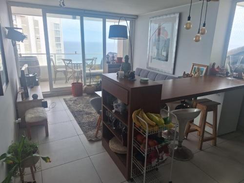 een keuken met een bureau en een woonkamer bij Dpto 2 piezas 2 baños al lado de las dunas de Concon in Viña del Mar