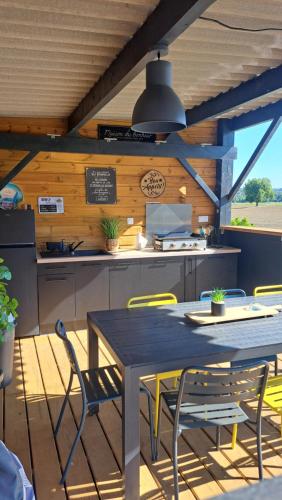 Una cocina con una mesa y sillas en una cocina. en Le Domaine Vesque, en Saint-Pierre-de-Clairac