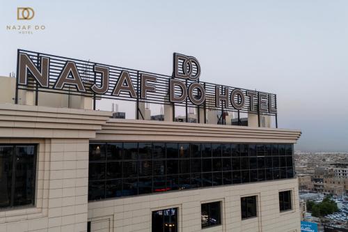 a building with a sign on top of it at Najaf Do Hotel in An Najaf
