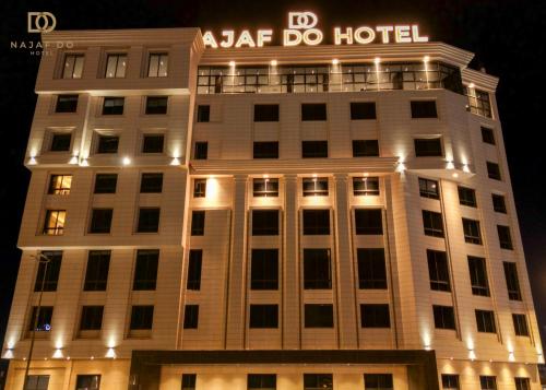 a building with a hotel sign on top of it at Najaf Do Hotel in An Najaf