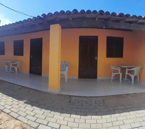 a building with tables and chairs in front of it at Suite da Barra in Barra Grande