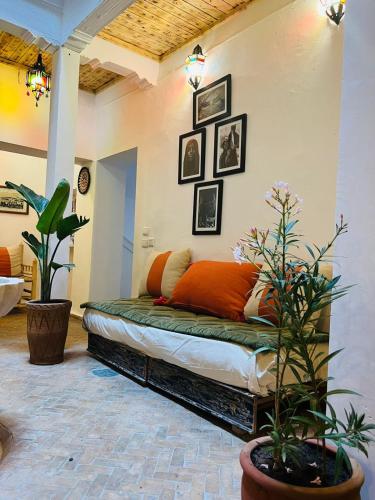 a bed in a room with pictures on the wall at Riyad zen oasis in Essaouira