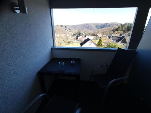 a window with a table and chairs in a room with a view at Wohnung Loggia 1 in Rurberg