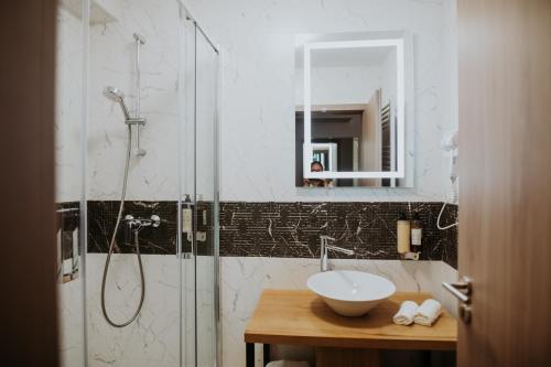 a bathroom with a shower with a sink and a sink at Hotel Epic Centrum in Cisnădie