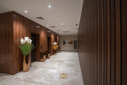 a hallway of a hotel with flowers in a vase at Najaf Do Hotel in An Najaf