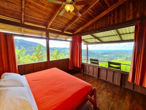 a bedroom with a bed and a large window at Santa Juana Lodge & Nature Reserve in Quepos