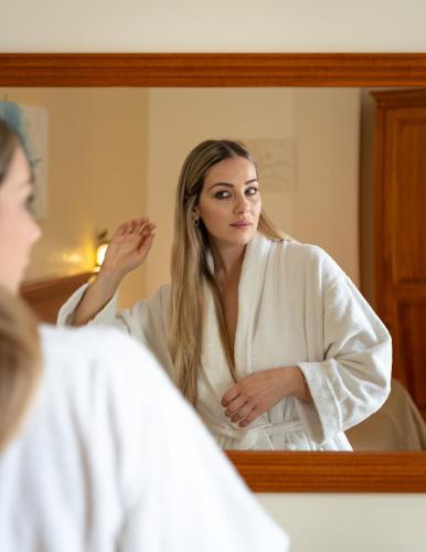 a woman looking at her reflection in a mirror at Domus Hotel in Bagnoli del Trigno