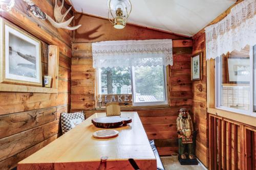 une salle à manger avec une table en bois et une fenêtre dans l'établissement Rustic Waterfront Cottage with Fire Pit and Kayaks, à Weare