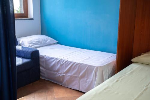 a small bedroom with two beds and a chair at Taormina Beach Front - Mazzeo in Mazzeo