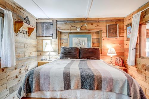 - une chambre avec un lit et des murs en bois dans l'établissement Rustic Waterfront Cottage with Fire Pit and Kayaks, à Weare