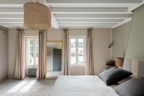 a bedroom with a bed and a large window at La bastide de Margaux in Soussans