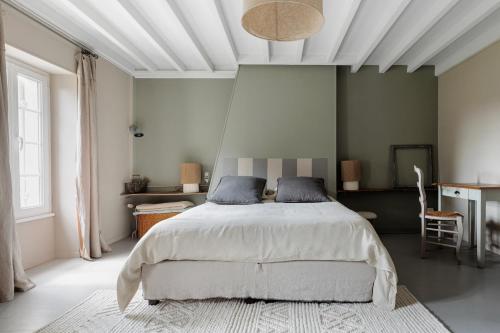 a bedroom with a bed and a white ceiling at La bastide de Margaux in Soussans