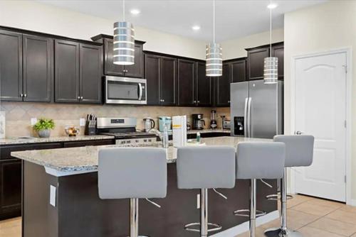 a kitchen with black cabinets and white appliances at Solterra Magic in Davenport