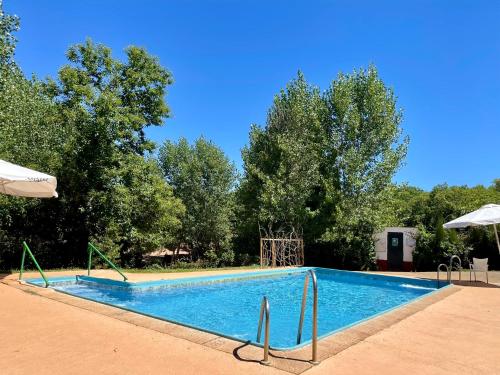 an empty swimming pool with trees in the background at Camping El Madroñal in Fuenteheridos