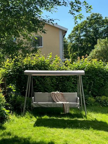 a bench sitting under a table in the grass at Haha Familjesol in Gothenburg