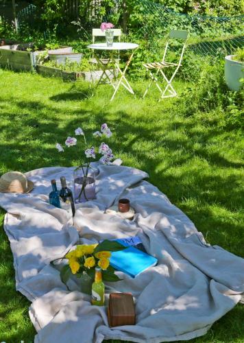 a blanket with bottles and flowers on it in the grass at Haha Familjesol in Gothenburg