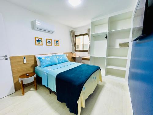 a bedroom with a blue bed and a closet at Apartamento dos Sonhos na Praia dos Anjos in Arraial do Cabo