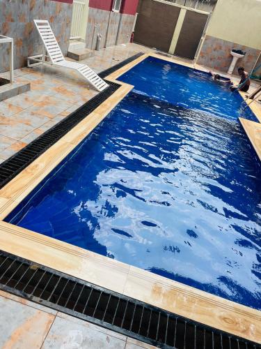 a swimming pool with blue water and wooden coping at Lavender Cozy apartment in Namugongo