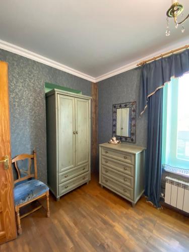 a bedroom with a dresser and a mirror and a chair at Cottage Kazka Lisu in Skhidnitsa