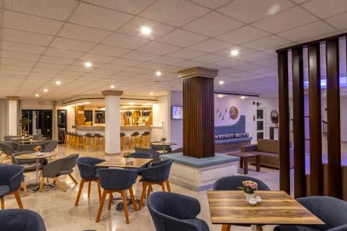 a restaurant with tables and chairs and a fireplace at Seagull Hotel Apartments in Protaras