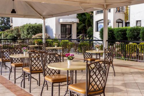 a row of tables and chairs under an umbrella on a patio at Seagull Hotel Apartments in Protaras