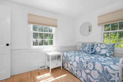 a bedroom with a bed and two windows at 78 Bucks Creek Road Chatham - Saltaire in Chatham