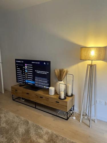 Une télévision à écran plat est installée au-dessus d'une table en bois. dans l'établissement Modern apartment with terrace, à Saint-Ouen