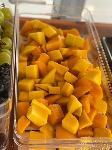 a plastic container filled with cut up mangoes and grapes at Deck Pousada in Carolina