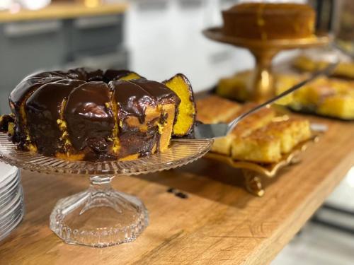 a chocolate cake on a glass plate on a table at Deck Pousada in Carolina