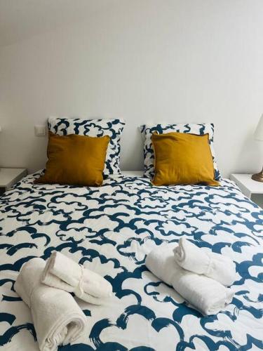 - un lit bleu et blanc avec des serviettes dans l'établissement Somptueux T3 neuf centre ville, à Sète