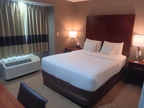 a hotel room with a large bed and a window at Comfort Inn & Suites in Aztec