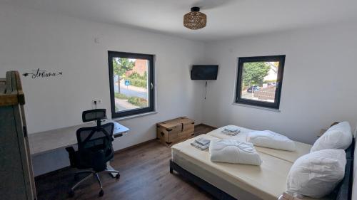 a bedroom with a bed and a desk and a chair at Ferienwohnung Lehmann 2 in Wolfenbüttel