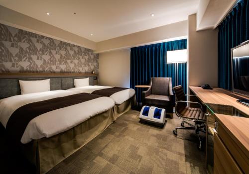 מיטה או מיטות בחדר ב-Daiwa Roynet Hotel Tokushima Ekimae