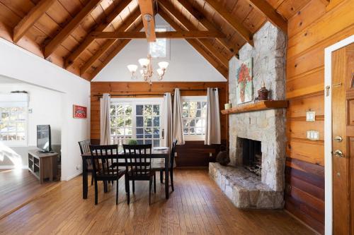 a dining room with a table and a fireplace at Gingerbread Gardens in Twin Peaks
