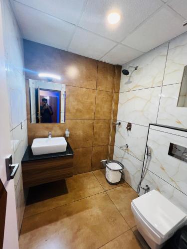 a bathroom with a sink and a toilet and a mirror at Shanthi Tourist Home in Pathanāmthitta