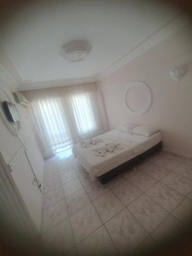 a white room with a bed and a mirror at Sacide OTEL in Didim
