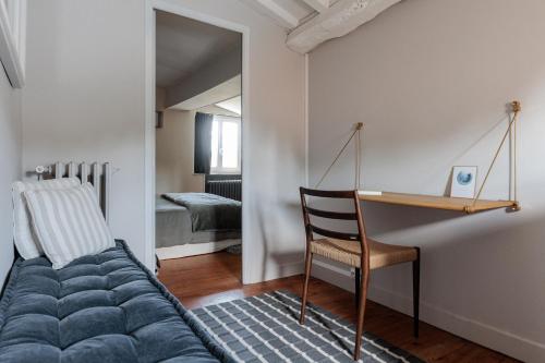 a bedroom with a bed and a desk and a chair at La bastide de Margaux in Soussans