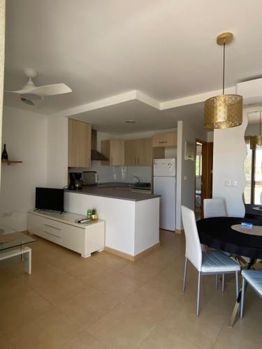 a kitchen and living room with a table and chairs at Condado de Alhama, Jardin 11 in Alhama de Murcia