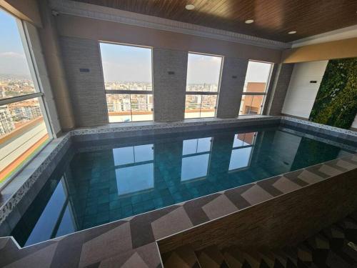 a swimming pool in a building with windows at Departamento en Cochabamba con hermosa vista in Calacala
