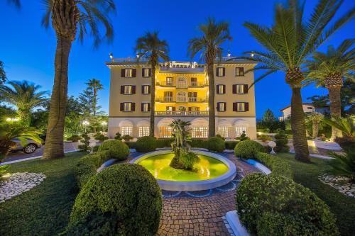 a mansion with a fountain in front of a building at La Medusa Hotel - Dimora di Charme in Castellammare di Stabia