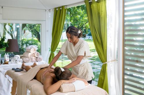 a woman laying on a bed getting a massage at La Medusa Hotel - Dimora di Charme in Castellammare di Stabia