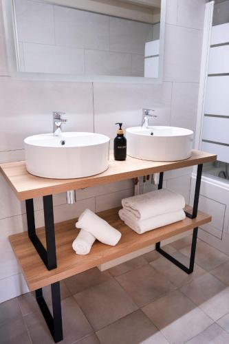 two sinks on a wooden shelf in a bathroom at La Bastide de Montferrat in Montferrat