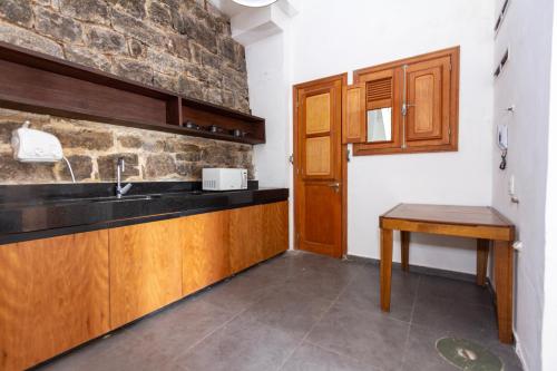 une cuisine avec des armoires en bois et un évier dans l'établissement Villa St Teresa do Porto: HarboursideVilla-SeaViews-Pool-BBQ-StarLink-6Bedrm, à Rio de Janeiro