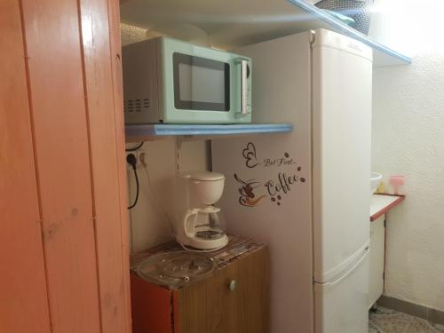 une petite cuisine avec un micro-ondes et un réfrigérateur dans l'établissement Studio location saisonnière de avril à fin octobre, à Agde