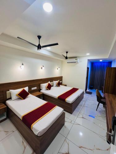 a hotel room with two beds and a desk at Shanthi Tourist Home in Pathanāmthitta